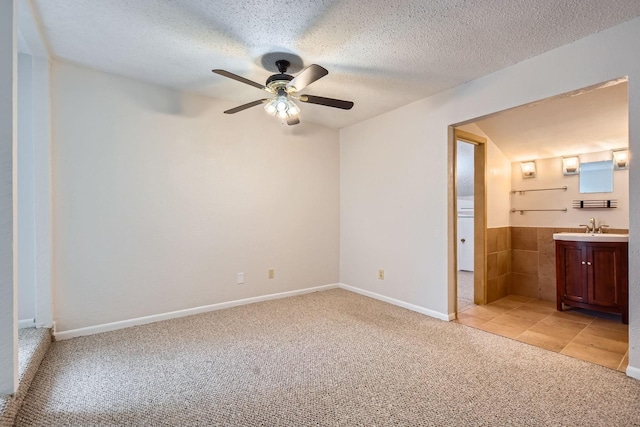 902 Via Valencia, Mesquite, TX 75150 - unfurnished bedroom featuring light carpet, ensuite bath, a textured ceiling, and a ceiling fan