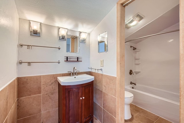 902 Via Valencia, Mesquite, TX 75150 - full bath with tile walls, vanity, shower / tub combination, a textured ceiling, and tile patterned floors