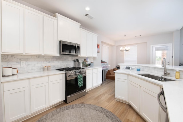 12720 Outlook Ave, Fort Worth, TX 76244 - kitchen featuring appliances with stainless steel finishes, a chandelier, backsplash, light wood finished floors, and recessed lighting