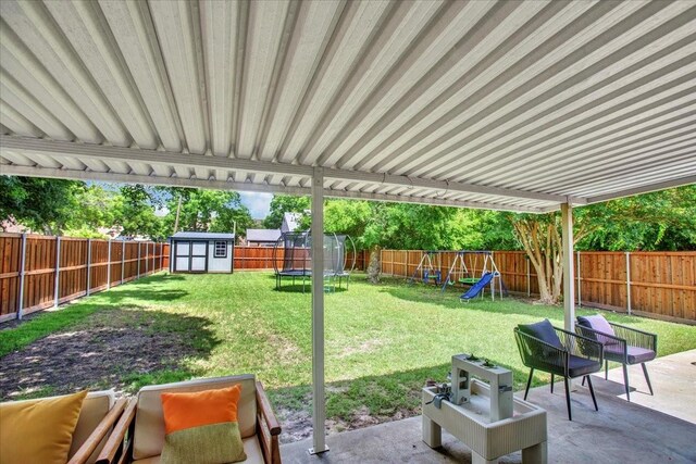 315 N Mckown Ave, Sherman, TX 75092 - fenced backyard featuring a trampoline, a storage unit, a patio, and a playground