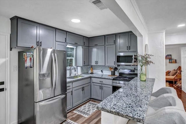 315 N Mckown Ave, Sherman, TX 75092 - kitchen featuring stainless steel appliances, gray cabinets, a peninsula, light wood finished floors, and recessed lighting
