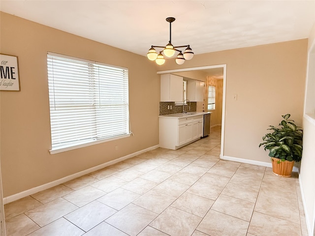 509 Cambridge, Richardson, TX 75080 - kitchen featuring white cabinetry, light countertops, a chandelier, decorative backsplash, and light tile patterned floors