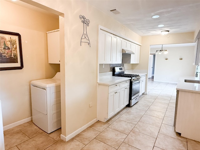 509 Cambridge, Richardson, TX 75080 - kitchen featuring stainless steel gas stove, washer / clothes dryer, light tile patterned floors, light countertops, and white cabinets