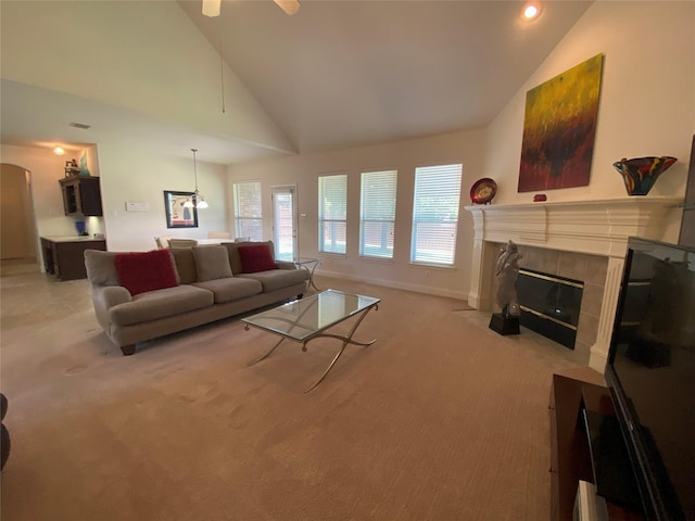 740 Bridgeport Ln, Prosper, TX 75078 - living room with light colored carpet, a tile fireplace, arched walkways, ceiling fan, and high vaulted ceiling
