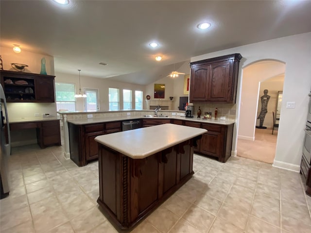 740 Bridgeport Ln, Prosper, TX 75078 - kitchen with a kitchen island, arched walkways, light countertops, dishwasher, and dark brown cabinets
