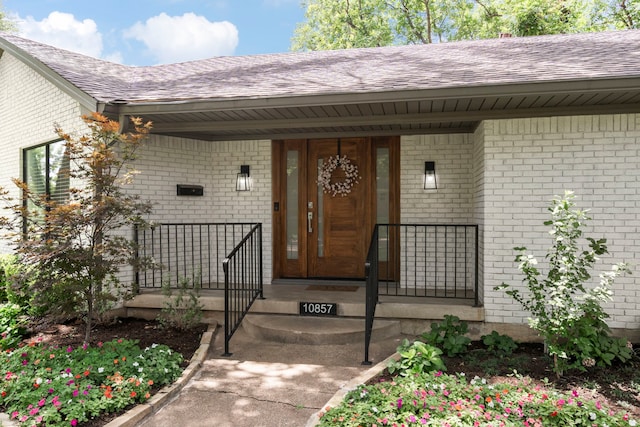 10857 Waterbridge Cir, Dallas, TX 75218 - property entrance featuring a shingled roof, brick siding, and a porch