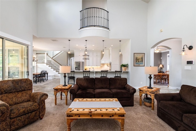 100 Redtail Hawk Dr, Aledo, TX 76008 - carpeted living area featuring stairs, a high ceiling, and arched walkways