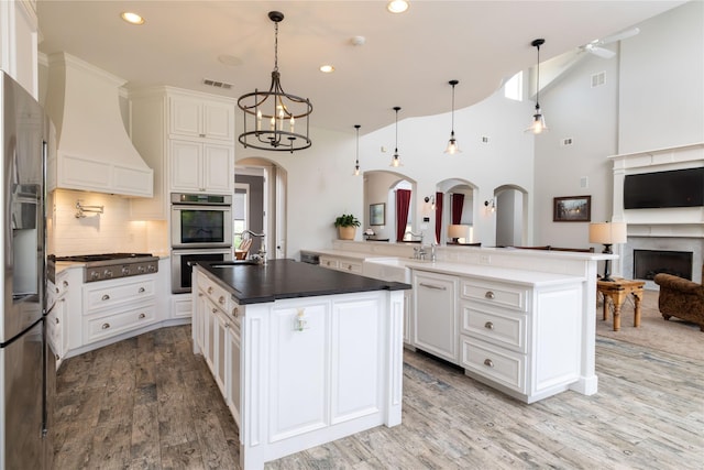 100 Redtail Hawk Dr, Aledo, TX 76008 - kitchen with appliances with stainless steel finishes, arched walkways, recessed lighting, open floor plan, and backsplash