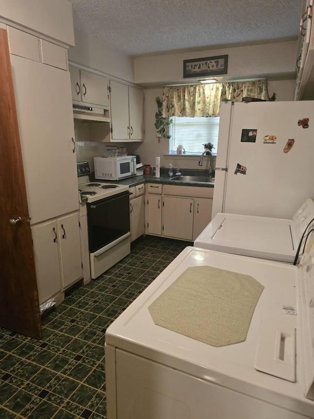 3916 Kushla Ave, Dallas, TX 75216 - kitchen with white appliances, under cabinet range hood, a textured ceiling, independent washer and dryer, and dark floors