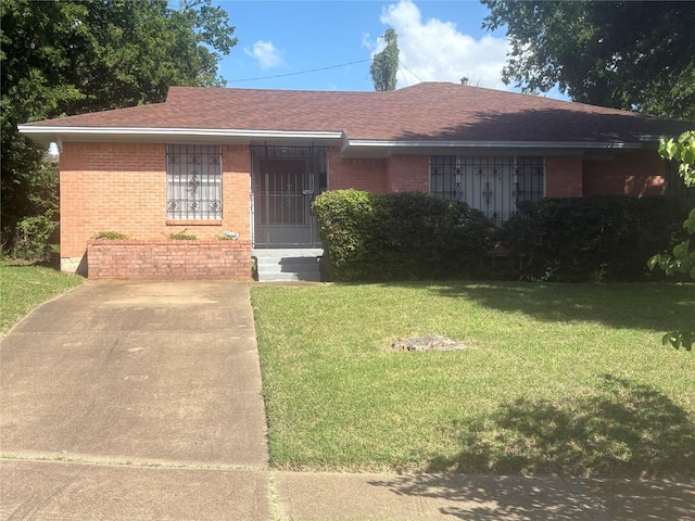 3916 Kushla Ave, Dallas, TX 75216 - view of front of home with brick siding, a front yard, and a shingled roof
