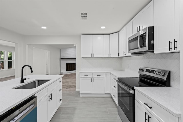 6401 Simmons Rd, North Richland Hills, TX 76182 - kitchen with appliances with stainless steel finishes, recessed lighting, white cabinetry, backsplash, and light stone countertops
