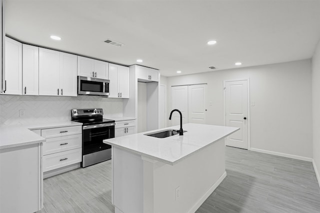 6401 Simmons Rd, North Richland Hills, TX 76182 - kitchen featuring appliances with stainless steel finishes, white cabinetry, tasteful backsplash, a kitchen island with sink, and recessed lighting