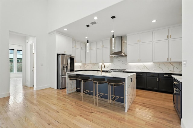 13868 Dorset Ln, Frisco, TX 75035 - kitchen featuring wall chimney exhaust hood, stainless steel refrigerator with ice dispenser, white cabinets, a kitchen bar, and tasteful backsplash