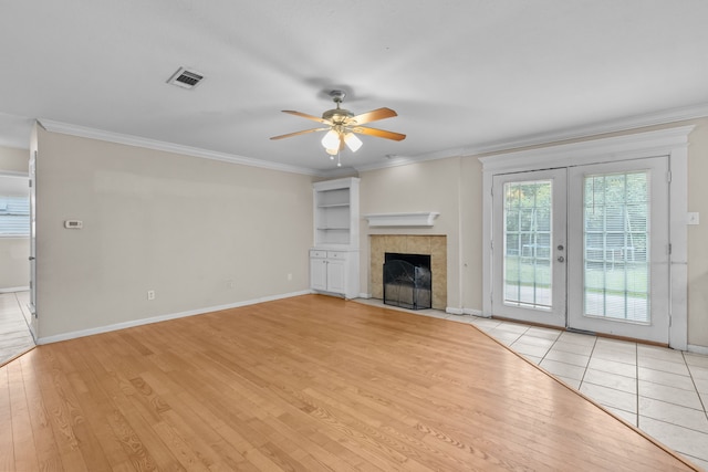 5308 Wentworth St, Fort Worth, TX 76132 - unfurnished living room with light wood-style flooring, ceiling fan, french doors, ornamental molding, and a tiled fireplace