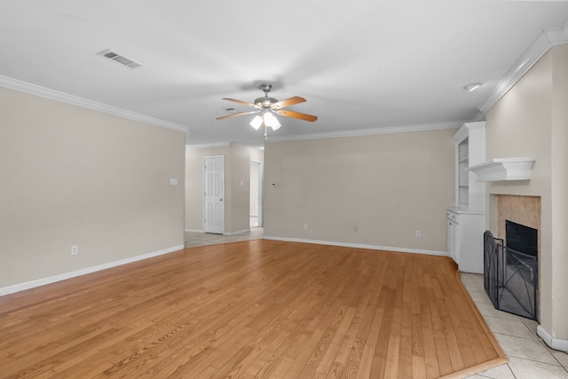 5308 Wentworth St, Fort Worth, TX 76132 - unfurnished living room featuring ceiling fan, crown molding, light wood-style floors, and a tile fireplace