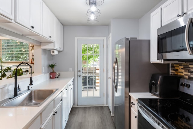 8805 Tumbleweed Dr, Cross Roads, TX 76227 - kitchen with stainless steel appliances, light wood-type flooring, white cabinets, and light countertops