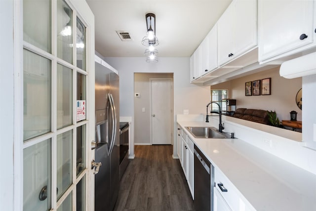 8805 Tumbleweed Dr, Cross Roads, TX 76227 - kitchen featuring appliances with stainless steel finishes, dark wood finished floors, white cabinetry, and hanging light fixtures