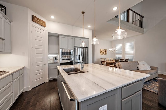 778 Corner Post Path, Celina, TX 75009 - kitchen with gray cabinets, appliances with stainless steel finishes, dark wood-type flooring, light stone countertops, and an island with sink