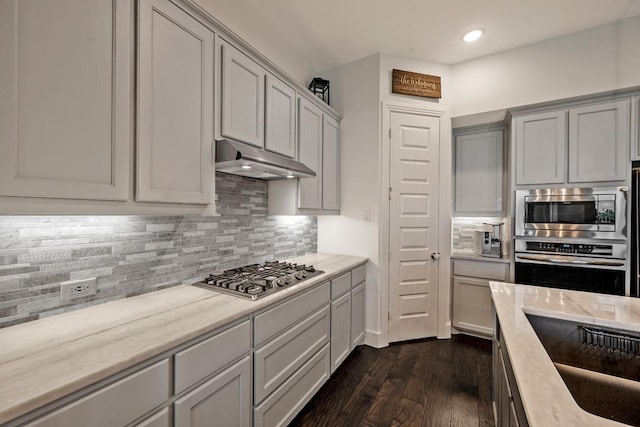 778 Corner Post Path, Celina, TX 75009 - kitchen with appliances with stainless steel finishes, under cabinet range hood, backsplash, dark wood-type flooring, and recessed lighting