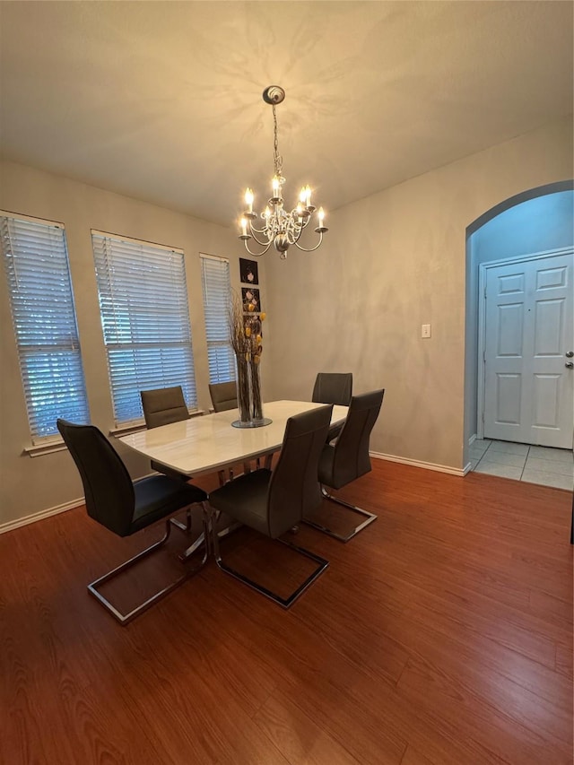 2100 Leandra Ln, Fort Worth, TX 76131 - dining area featuring a chandelier, arched walkways, and light wood finished floors