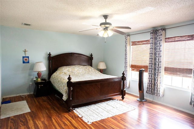 1313 Forbes Dr, Garland, TX 75040 - bedroom featuring wood finished floors, a textured ceiling, and a ceiling fan