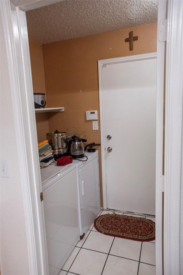 1313 Forbes Dr, Garland, TX 75040 - laundry room with washer and dryer, light tile patterned floors, and a textured ceiling