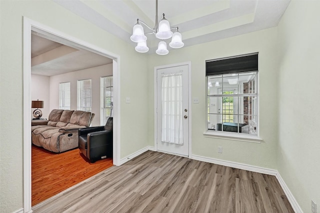 2107 Meadows Cir, Sherman, TX 75092 - foyer entrance featuring wood finished floors, plenty of natural light, a chandelier, and a tray ceiling