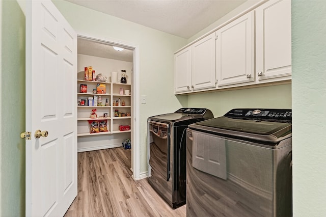2107 Meadows Cir, Sherman, TX 75092 - laundry area featuring independent washer and dryer, light wood finished floors, cabinet space, and a textured ceiling