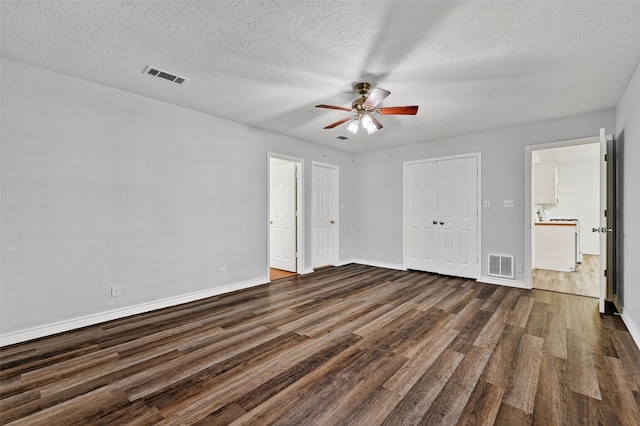 2107 Meadows Cir, Sherman, TX 75092 - unfurnished bedroom featuring dark wood-style flooring, a textured ceiling, a closet, a ceiling fan, and connected bathroom