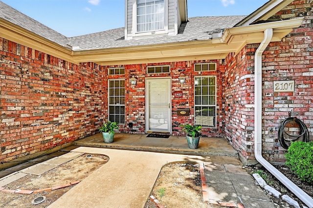 2107 Meadows Cir, Sherman, TX 75092 - property entrance with brick siding, a porch, and a shingled roof