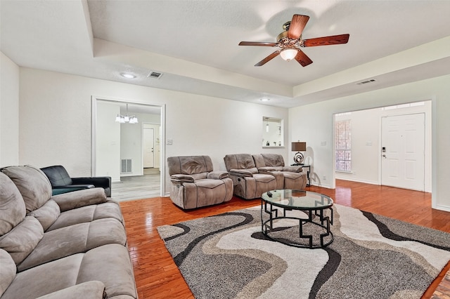 2107 Meadows Cir, Sherman, TX 75092 - living area featuring wood finished floors, a ceiling fan, a tray ceiling, a chandelier, and recessed lighting