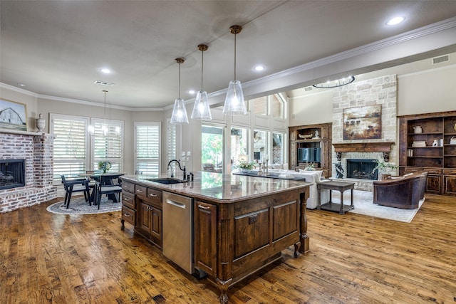 2521 Fair Oaks Ln, Prosper, TX 75078 - kitchen with a fireplace, dishwasher, dark brown cabinetry, wood finished floors, and ornamental molding