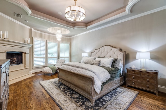 2521 Fair Oaks Ln, Prosper, TX 75078 - bedroom with wood finished floors, a raised ceiling, crown molding, a chandelier, and a fireplace