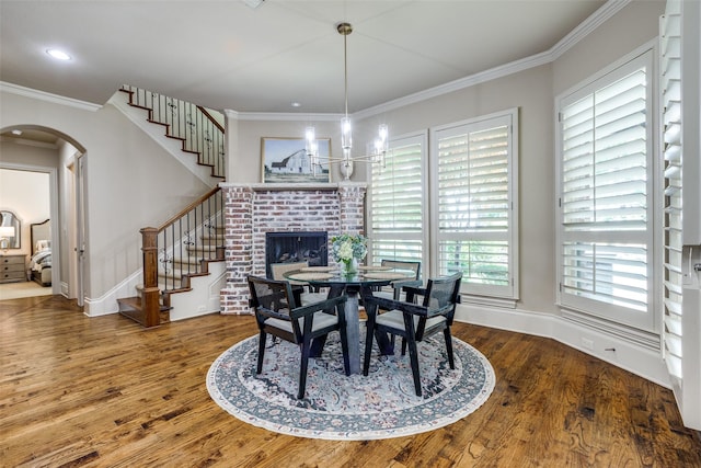 2521 Fair Oaks Ln, Prosper, TX 75078 - dining room with arched walkways, wood finished floors, stairway, ornamental molding, and a fireplace