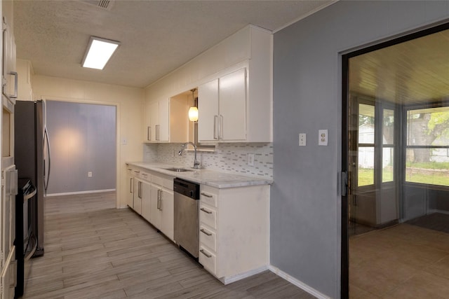 740 Willow St, Hurst, TX 76053 - kitchen with stainless steel dishwasher, light countertops, white cabinets, decorative backsplash, and light wood finished floors