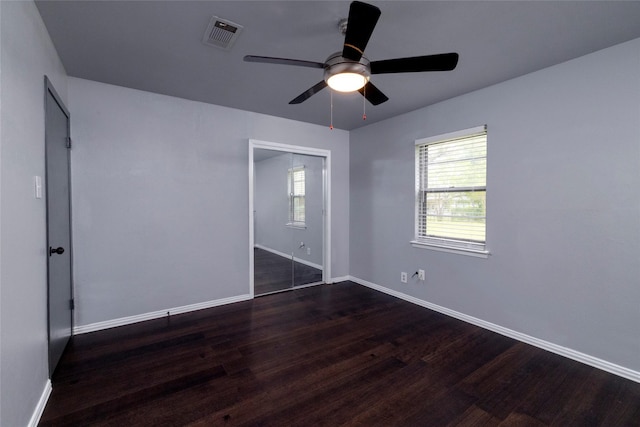 740 Willow St, Hurst, TX 76053 - unfurnished bedroom with dark wood finished floors, multiple windows, and ceiling fan