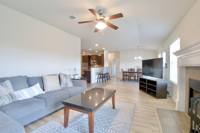 9929 Caney Creek Dr, Waco, TX 76708 - living room with lofted ceiling, ceiling fan, light wood finished floors, and a tile fireplace