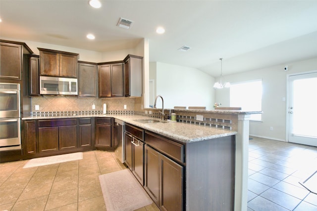 9929 Caney Creek Dr, Waco, TX 76708 - kitchen with appliances with stainless steel finishes, tasteful backsplash, light tile patterned floors, dark brown cabinets, and recessed lighting
