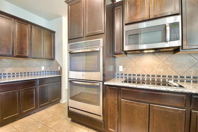 9929 Caney Creek Dr, Waco, TX 76708 - kitchen with appliances with stainless steel finishes, tasteful backsplash, dark brown cabinets, light tile patterned floors, and light stone counters
