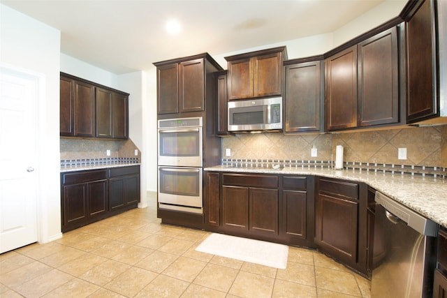 9929 Caney Creek Dr, Waco, TX 76708 - kitchen featuring stainless steel appliances, tasteful backsplash, dark brown cabinetry, and light tile patterned floors