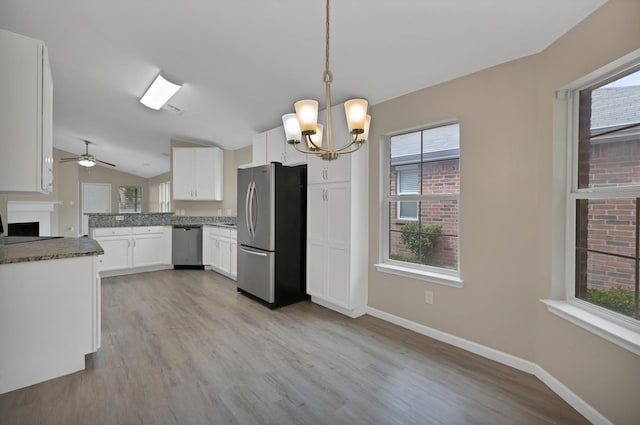 8805 Highland Orchard Dr, Fort Worth, TX 76179 - kitchen with stainless steel appliances, a chandelier, white cabinetry, vaulted ceiling, and light wood-style floors
