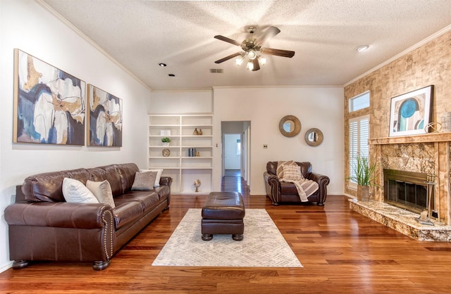3104 Park Garden Pl, Richardson, TX 75082 - living area with ornamental molding, a textured ceiling, a ceiling fan, wood finished floors, and built in shelves