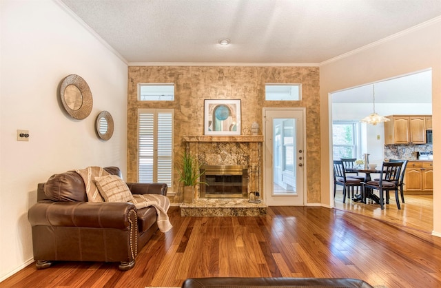 3104 Park Garden Pl, Richardson, TX 75082 - living room with a high end fireplace, wood finished floors, ornamental molding, a chandelier, and a textured ceiling