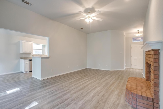 692 High Crest Dr, Azle, TX 76020 - unfurnished living room featuring ceiling fan, plenty of natural light, light wood-style floors, and a fireplace