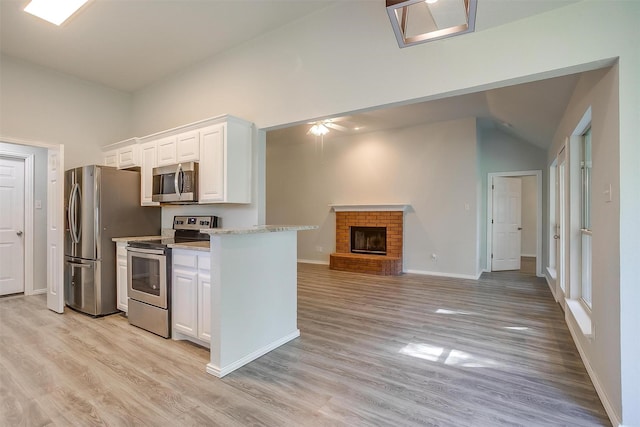 692 High Crest Dr, Azle, TX 76020 - kitchen with appliances with stainless steel finishes, lofted ceiling, white cabinets, and light wood-style flooring