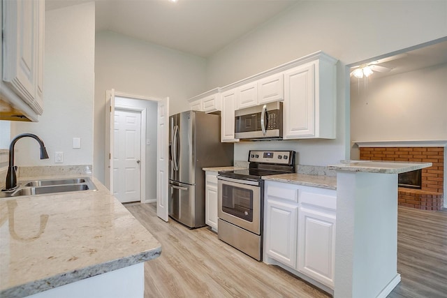 692 High Crest Dr, Azle, TX 76020 - kitchen featuring appliances with stainless steel finishes, light wood finished floors, white cabinetry, a ceiling fan, and vaulted ceiling