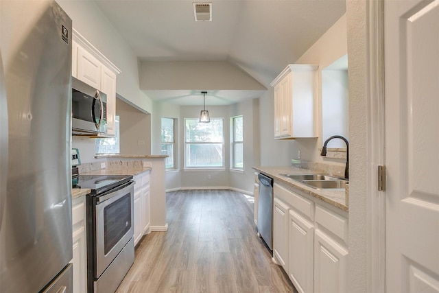 692 High Crest Dr, Azle, TX 76020 - kitchen featuring stainless steel appliances, light wood finished floors, white cabinets, lofted ceiling, and decorative light fixtures