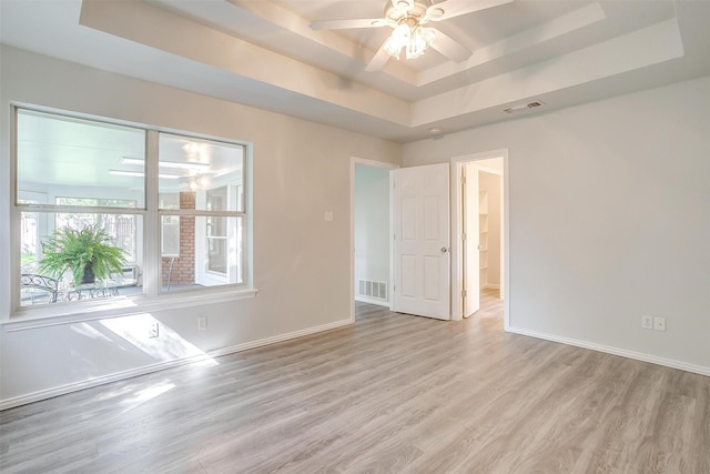 692 High Crest Dr, Azle, TX 76020 - empty room featuring a raised ceiling, wood finished floors, and a ceiling fan