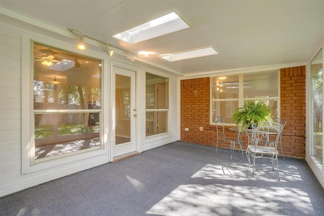 692 High Crest Dr, Azle, TX 76020 - unfurnished sunroom featuring brick wall, carpet floors, a skylight, and track lighting