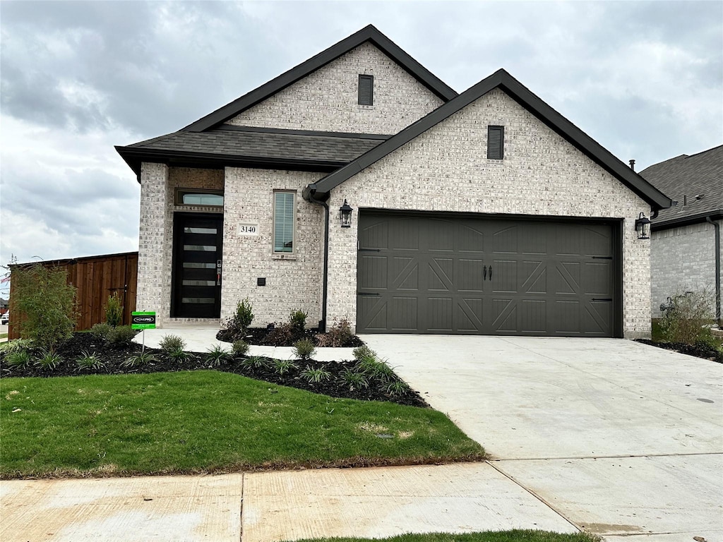3140 Brazoria Dr, Little Elm, TX 75068 - french country style house featuring a garage, brick siding, driveway, and a front lawn